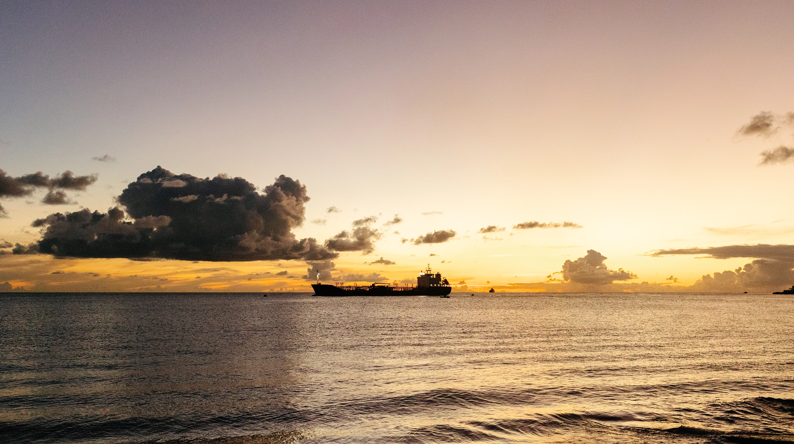 Cargo ship on the ocean at sunset